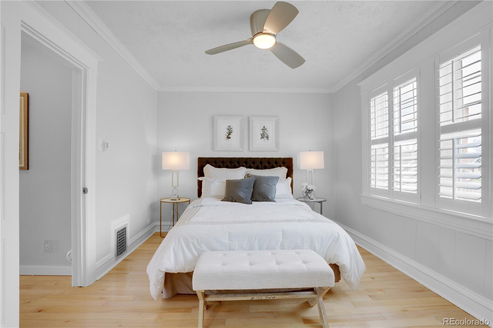 1283 Madison Street Denver, CO 80206 - Photo 16 of 34 a bedroom with a bed and wooden floor