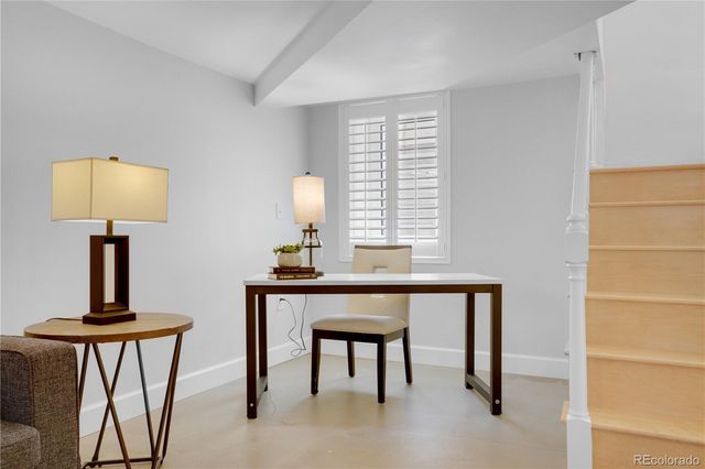 a view of a workspace with furniture and a window