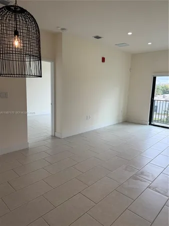 a view of empty room with wooden floor and window