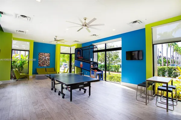 a living room with a flat screen tv furniture and a potted plant