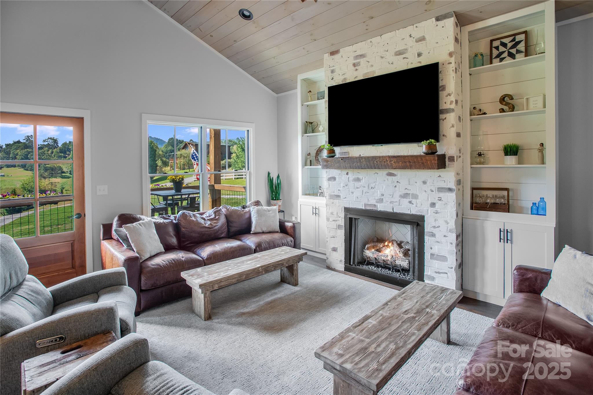 100 Kinloch Lane Clyde, NC 28721 - Photo 5 of 39 a living room with furniture a flat screen tv and a fireplace