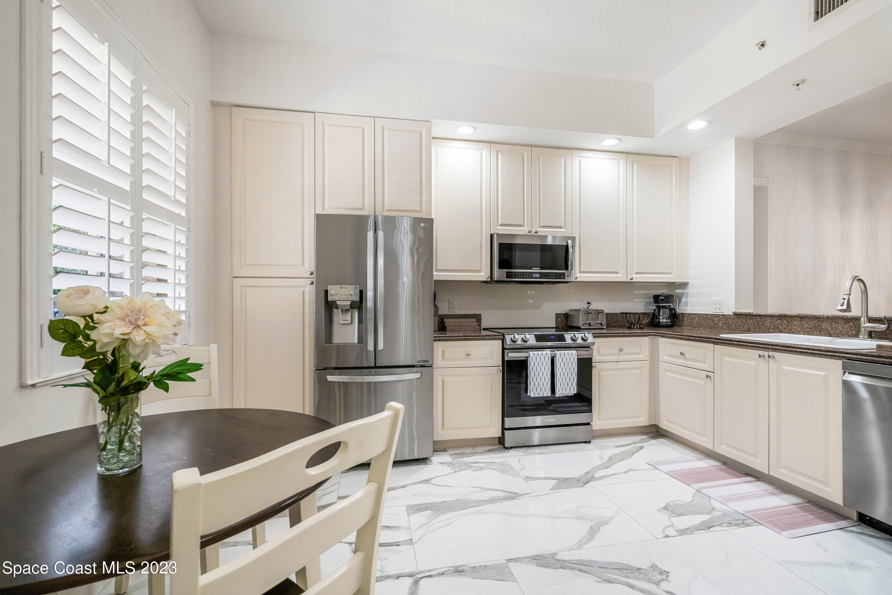 Undisclosed Address Fort Pierce, FL 34949 - Photo 3 of 36 a kitchen with stainless steel appliances granite countertop a refrigerator a stove a sink a microwave a dining table and chairs