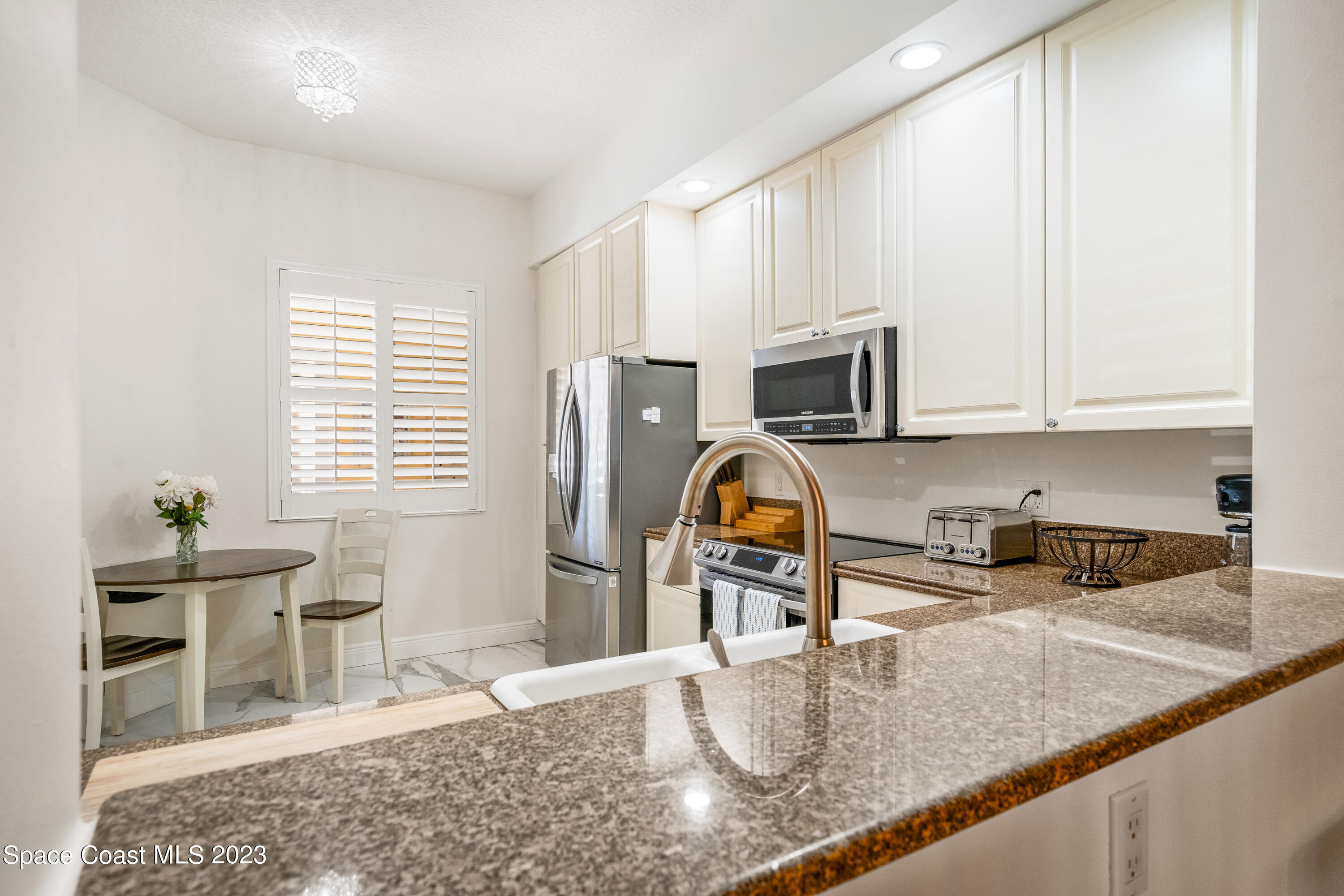 Undisclosed Address Fort Pierce, FL 34949 - Photo 7 of 36 a kitchen with granite countertop a stove a sink and a microwave