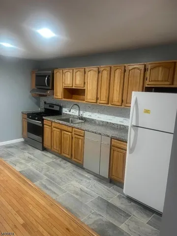a kitchen with stainless steel appliances granite countertop a stove a sink and a refrigerator