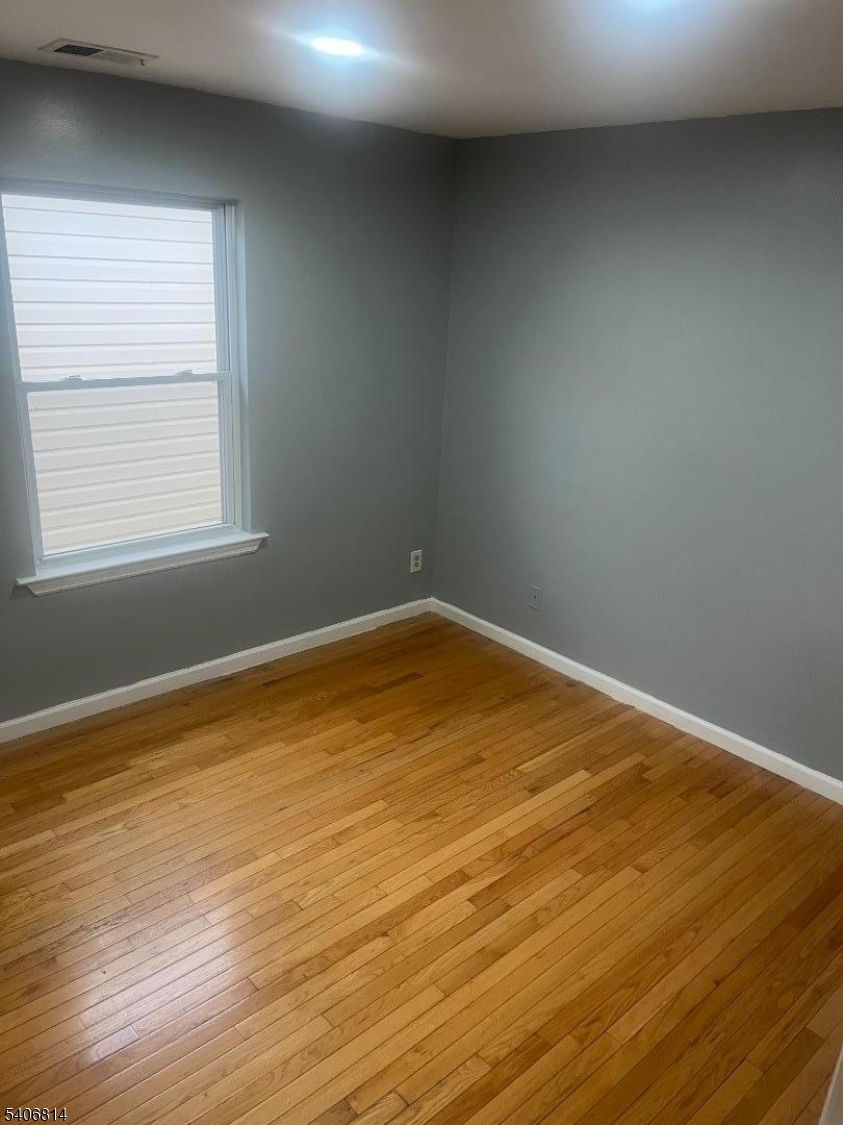 710 27th Street Union City, NJ 07087 - Photo 7 of 22 an empty room with wooden floor and windows