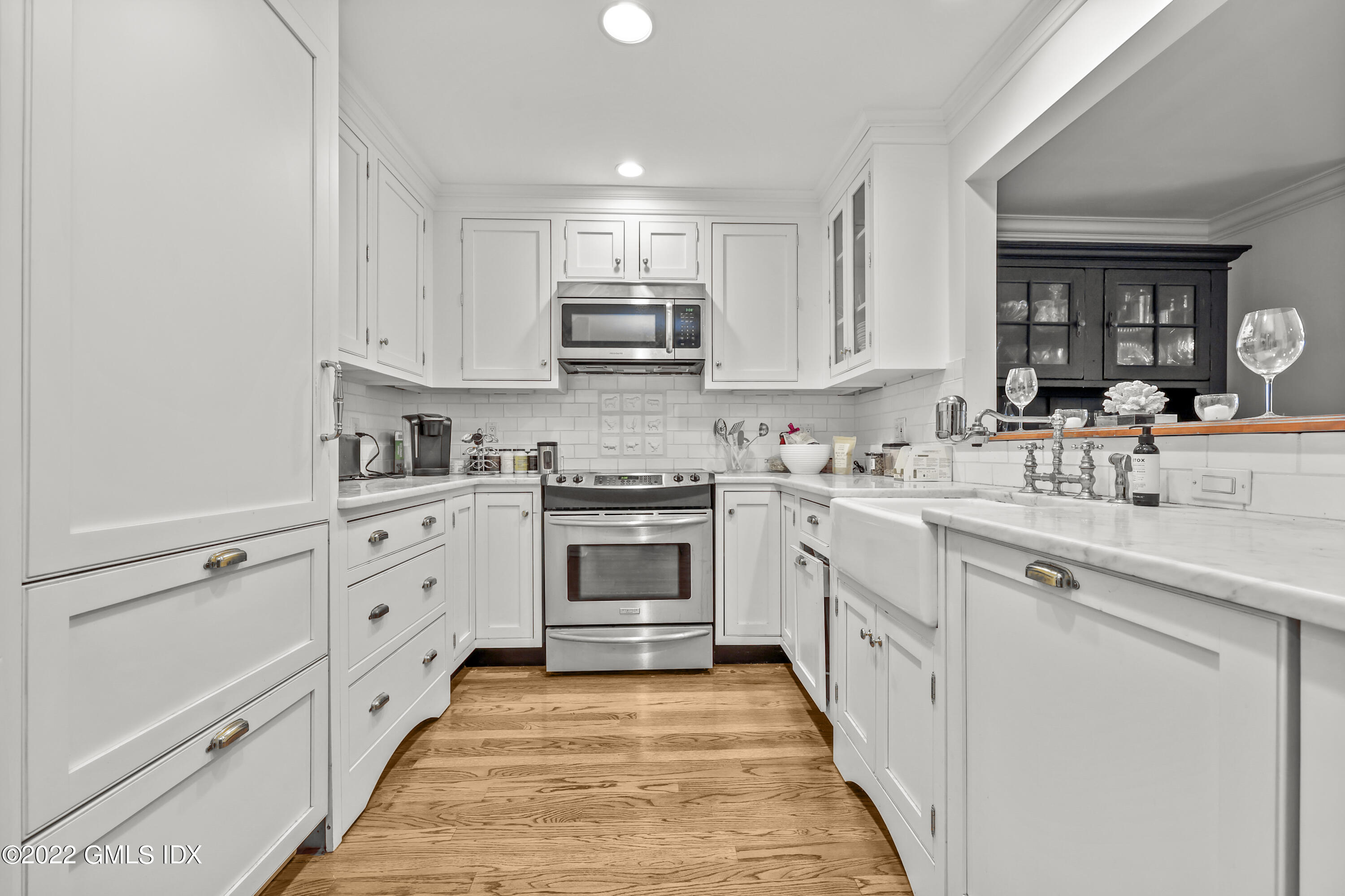 15 River Road, Unit 211 Cos Cob, CT 06807 - Photo 3 of 21 a kitchen with white cabinets appliances and sink