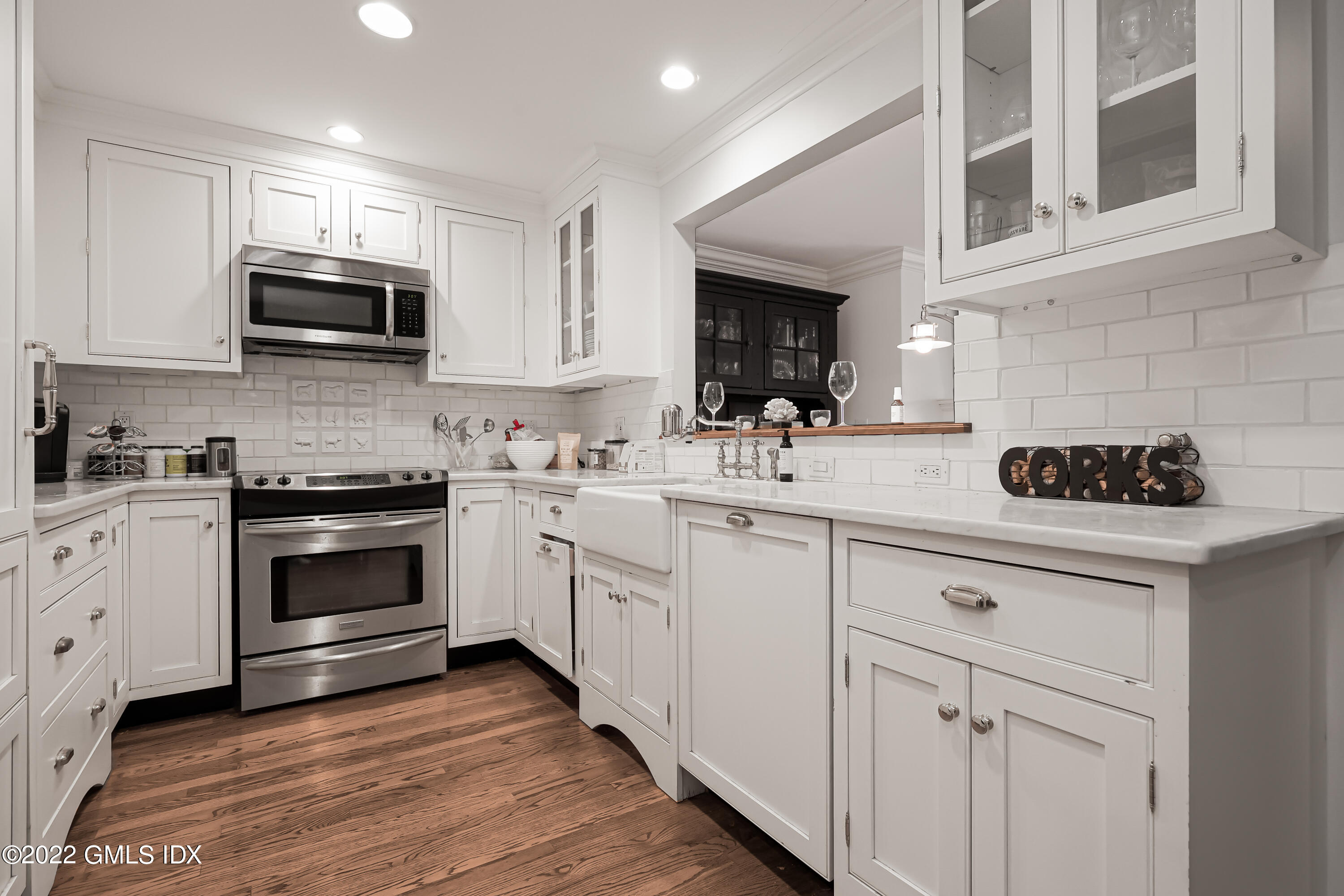 15 River Road, Unit 211 Cos Cob, CT 06807 - Photo 4 of 21 a kitchen with white cabinets stainless steel appliances and sink