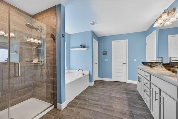 a bathroom with a tub shower and sink