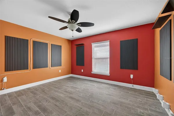 a view of an empty room with a window and a ceiling fan