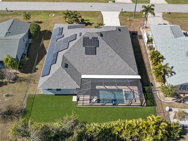 an aerial view of a house with a garden and lake view