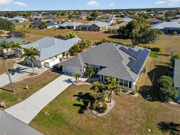 an aerial view of a house with yard swimming pool and ocean view