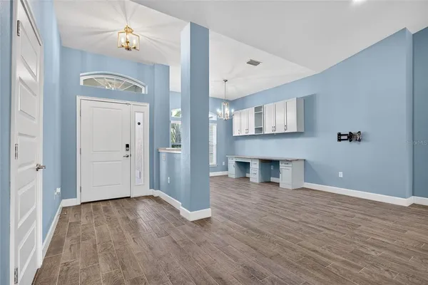 a view of a big room with wooden floor and windows