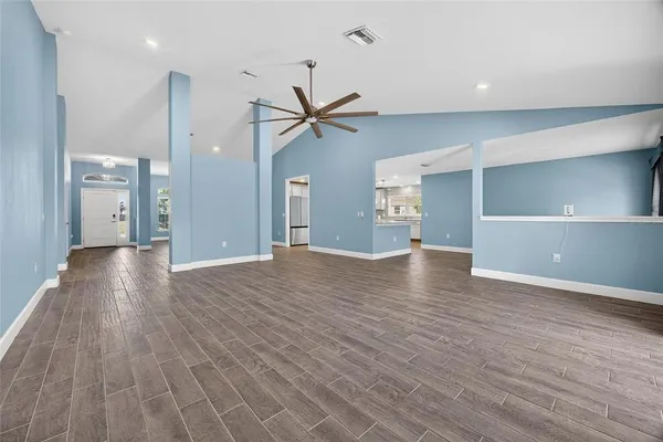 a view of a room with wooden floor and a ceiling fan