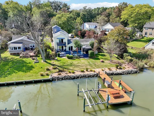 an aerial view of a house with swimming pool and lake view