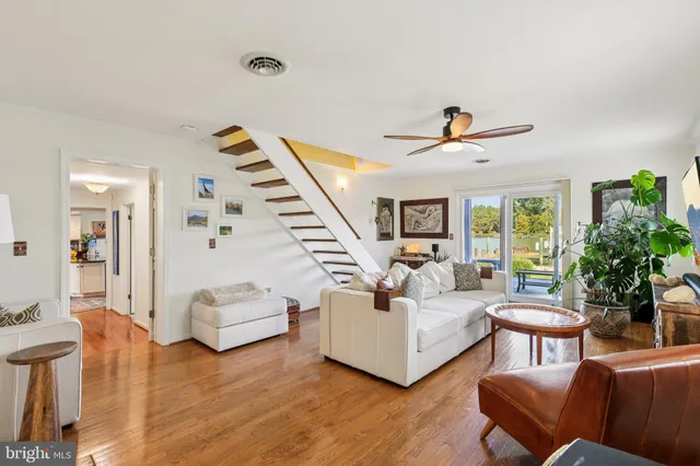 a living room with furniture a bookshelf and a flat screen tv