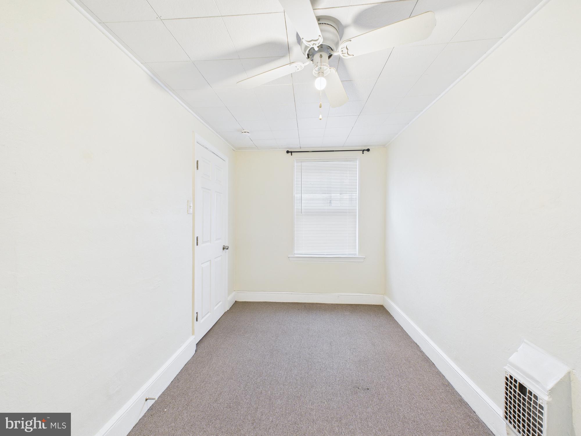 1825 Carlton Street Philadelphia, PA 19103 - Photo 19 of 28 an empty room with a ceiling fan and a window