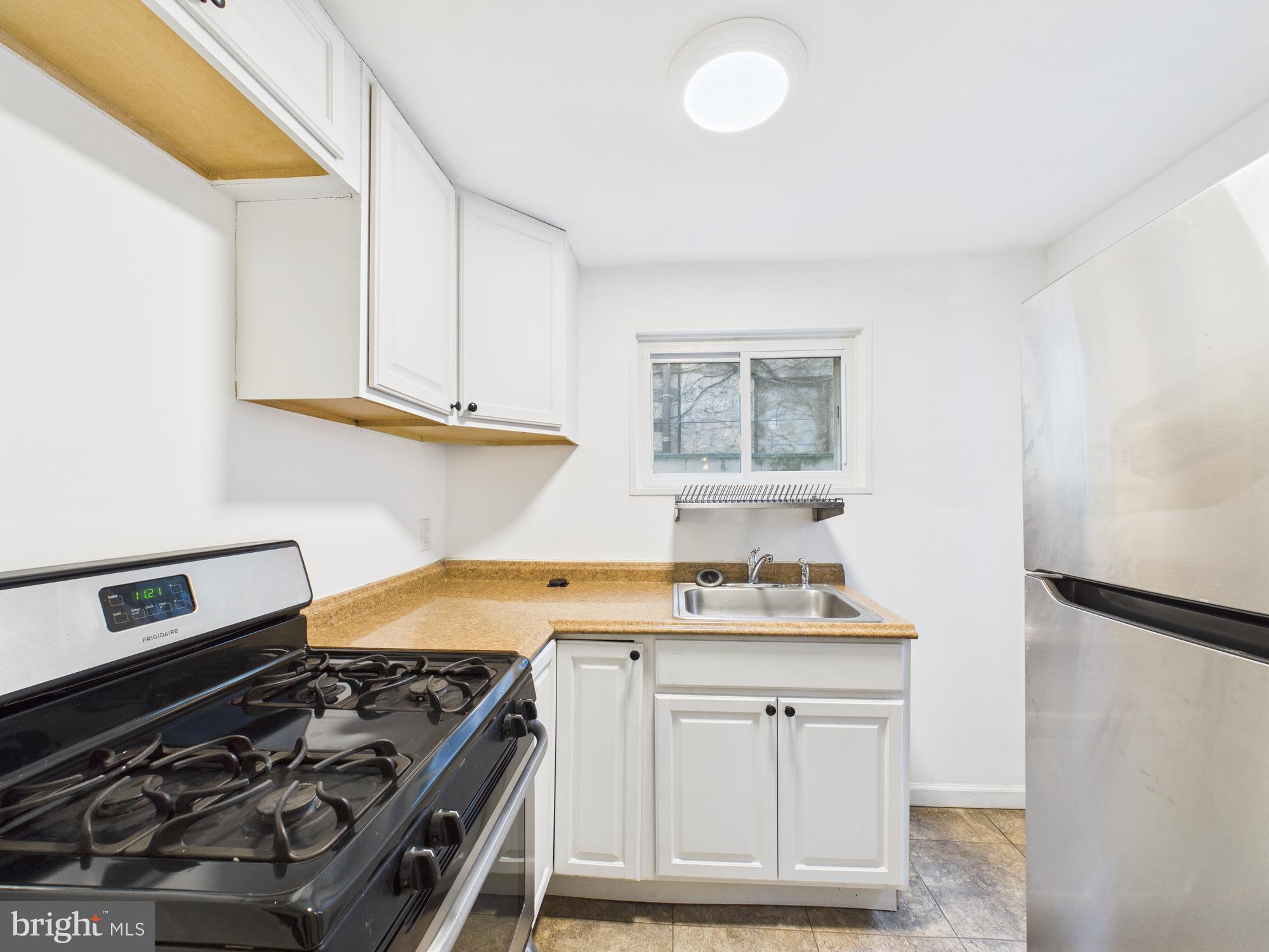 1825 Carlton Street Philadelphia, PA 19103 - Photo 4 of 28 a kitchen with white cabinets and appliances