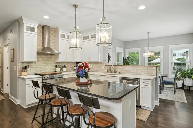 a kitchen with stainless steel appliances granite countertop a kitchen island a stove a table and chairs in it