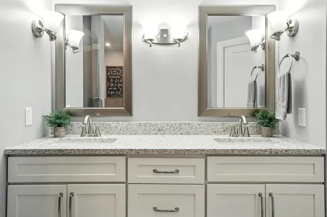 a bathroom with a granite countertop sink and a mirror
