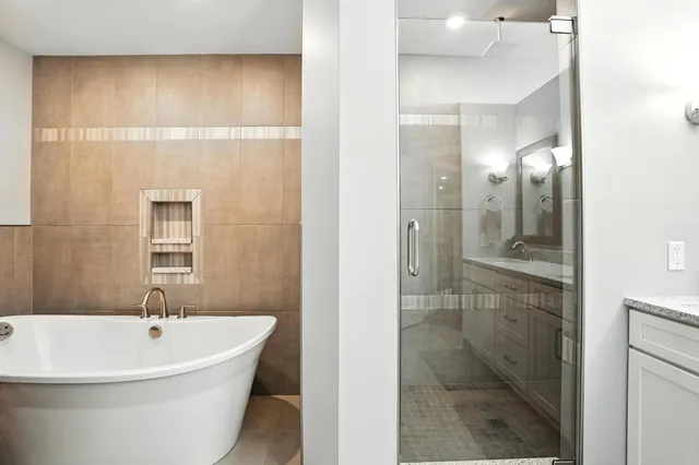a white bath tub sitting next to a bathroom sink
