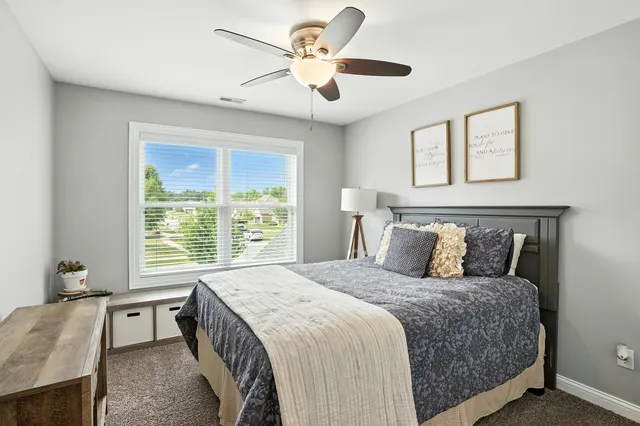 a bedroom with a large bed and a chandelier