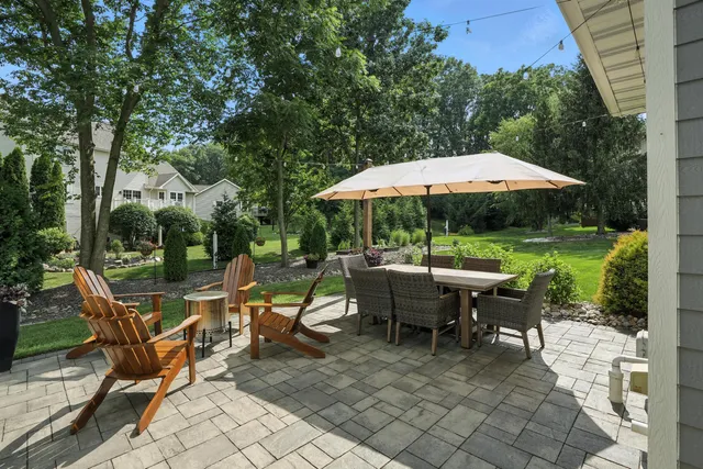 a view of a patio with table and chairs under an umbrella