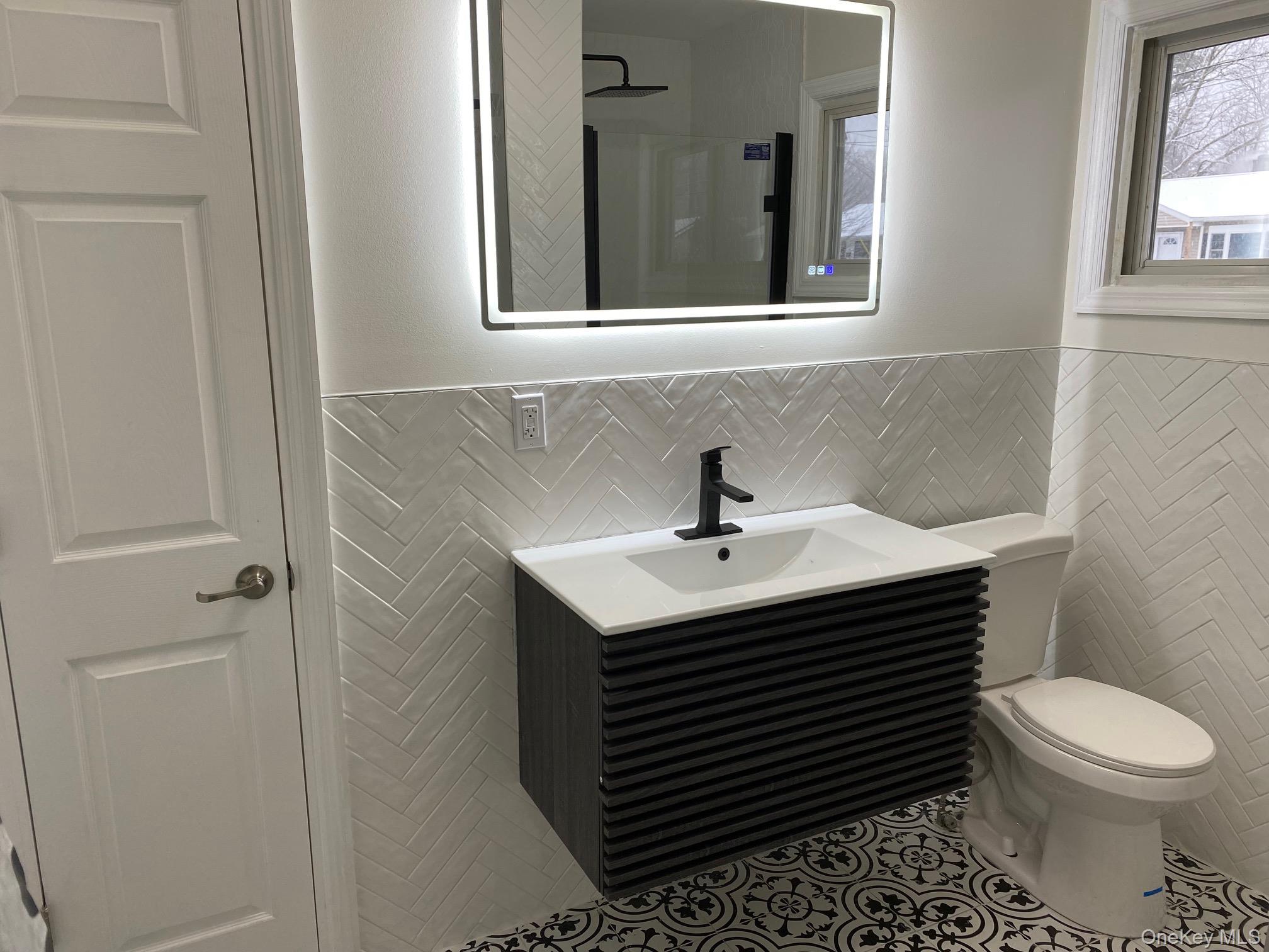 5 Smith Road Cornwall, NY 12518 - Photo 19 of 32 Full bathroom featuring vanity, tile walls, tile patterned flooring, wainscoting, and a shower