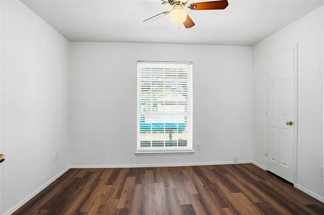 an empty room with a window and wooden floor