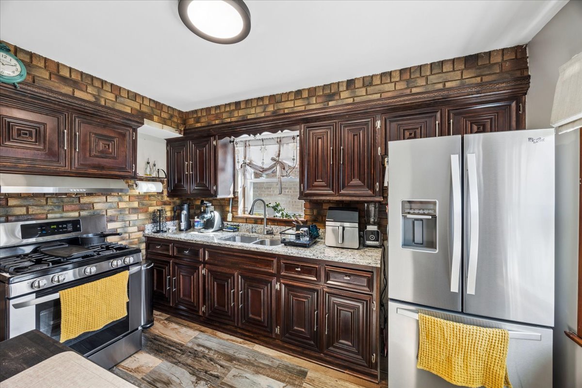 6140 South Kostner Avenue Chicago, IL 60629 - Photo 8 of 24 a kitchen with stainless steel appliances granite countertop a refrigerator a stove a sink and a microwave
