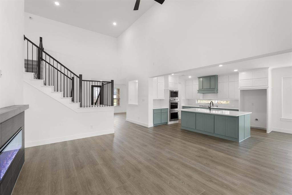 413 Tower Street DeSoto, TX 75115 - Photo 11 of 30 a living room with stainless steel appliances kitchen island wooden floors and white walls