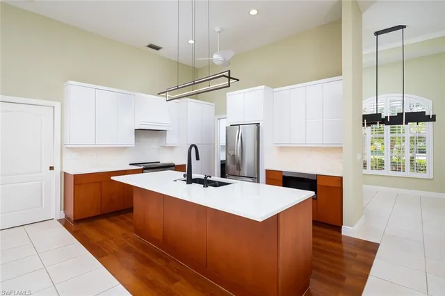a kitchen with stainless steel appliances granite countertop a sink a stove and a refrigerator