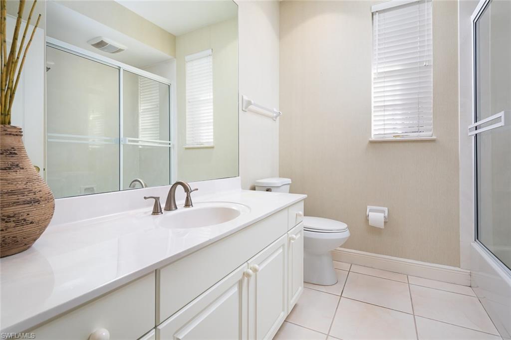 6900 Mill Run Road Naples, FL 34109 - Photo 23 of 31 a bathroom with a sink a toilet and a mirror