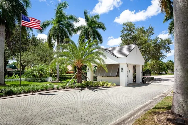 a view of a house with a yard and palm trees