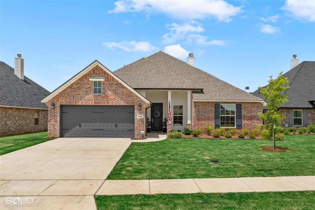 304 Prien Lk Loop Bossier City, LA 71111 - Photo 1 of 39 Brick exterior with white columns and a dark gray garage door