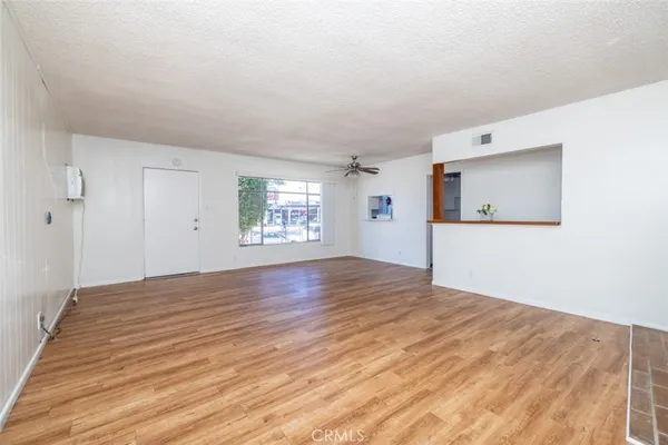 a view of empty room with wooden floor and windows