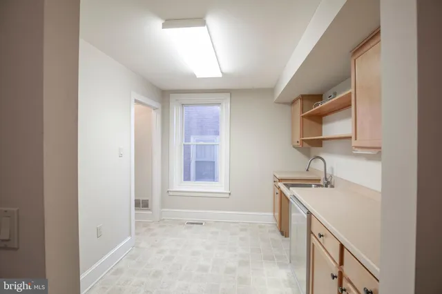 a view of an empty room with stairs and a window