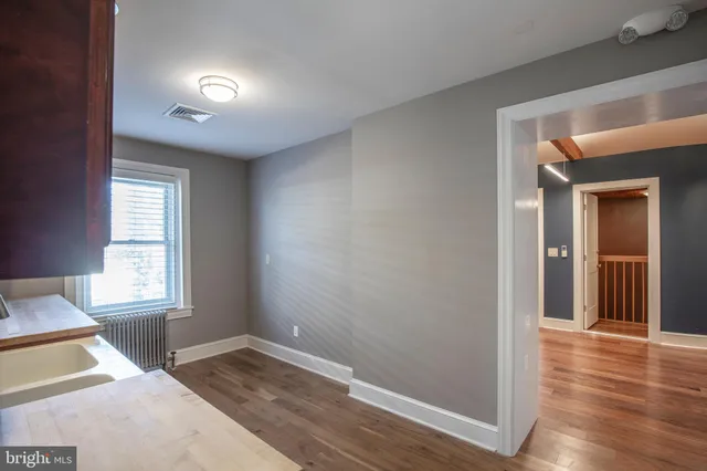 a view of a room with wooden floor and a window