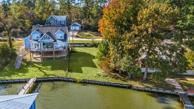 an aerial view of a house with swimming pool and lake view