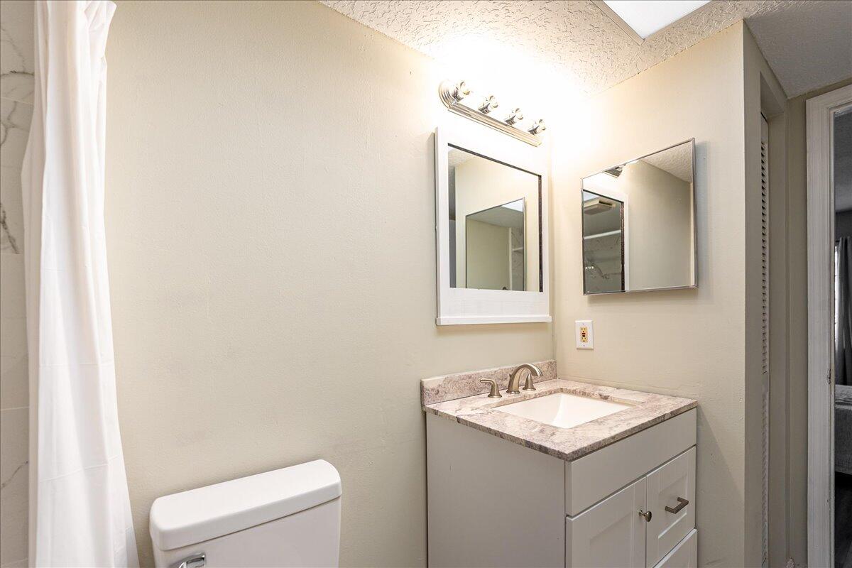 950 South Kanner Highway, Unit E4 Stuart, FL 34994 - Photo 16 of 33 a bathroom with a granite countertop sink and a toilet