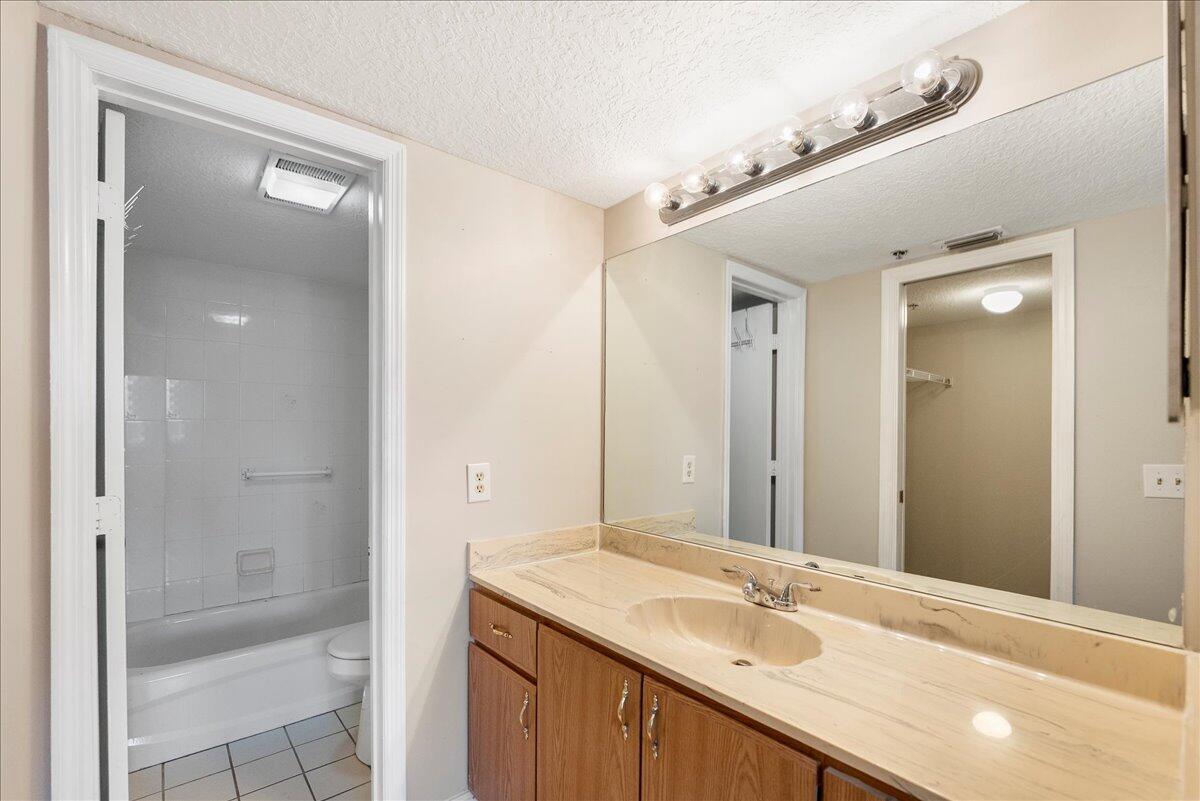 950 South Kanner Highway, Unit E4 Stuart, FL 34994 - Photo 9 of 33 a bathroom with a granite countertop sink mirror and shower