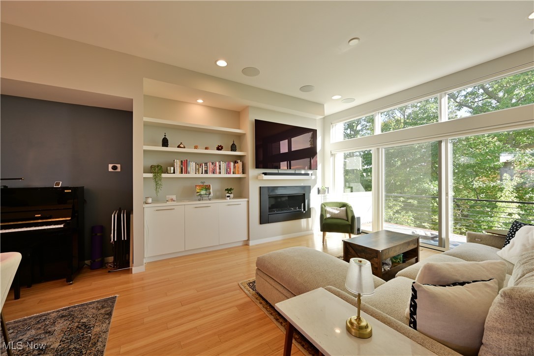 18875 Riversouth Fairview Park, Unit 30 Cleveland, OH 44126 - Photo 6 of 39 Living room with light wood-style floors, recessed lighting, a glass covered fireplace, and built in shelves
