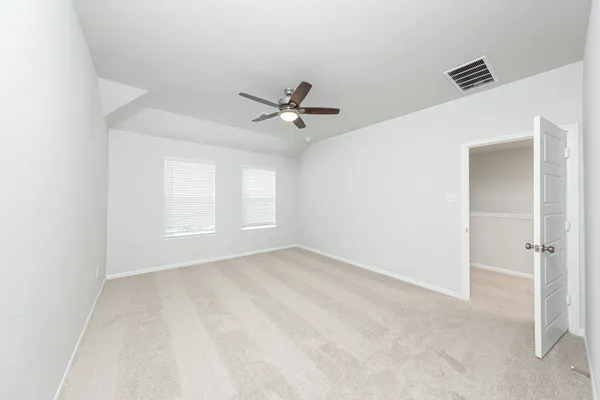 a view of a room with a ceiling fan and wooden floor