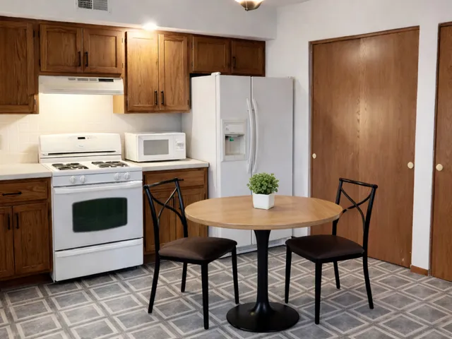 a kitchen with stainless steel appliances a stove a refrigerator a dining table and chairs