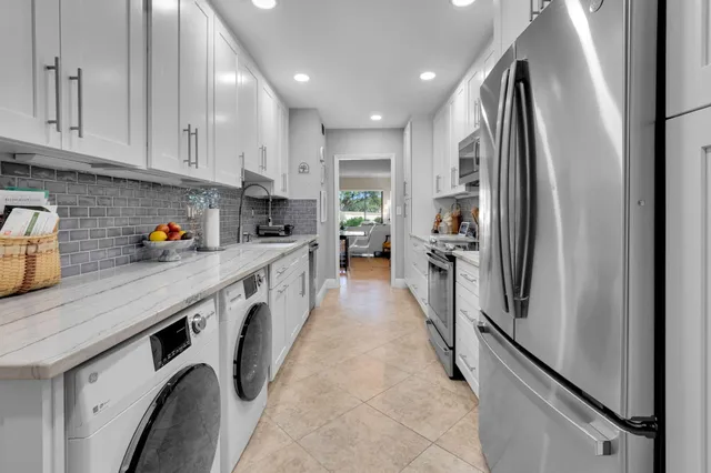 a kitchen with stainless steel appliances granite countertop a refrigerator and a stove