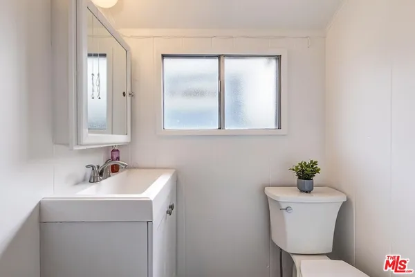 a bathroom with a sink toilet and a mirror
