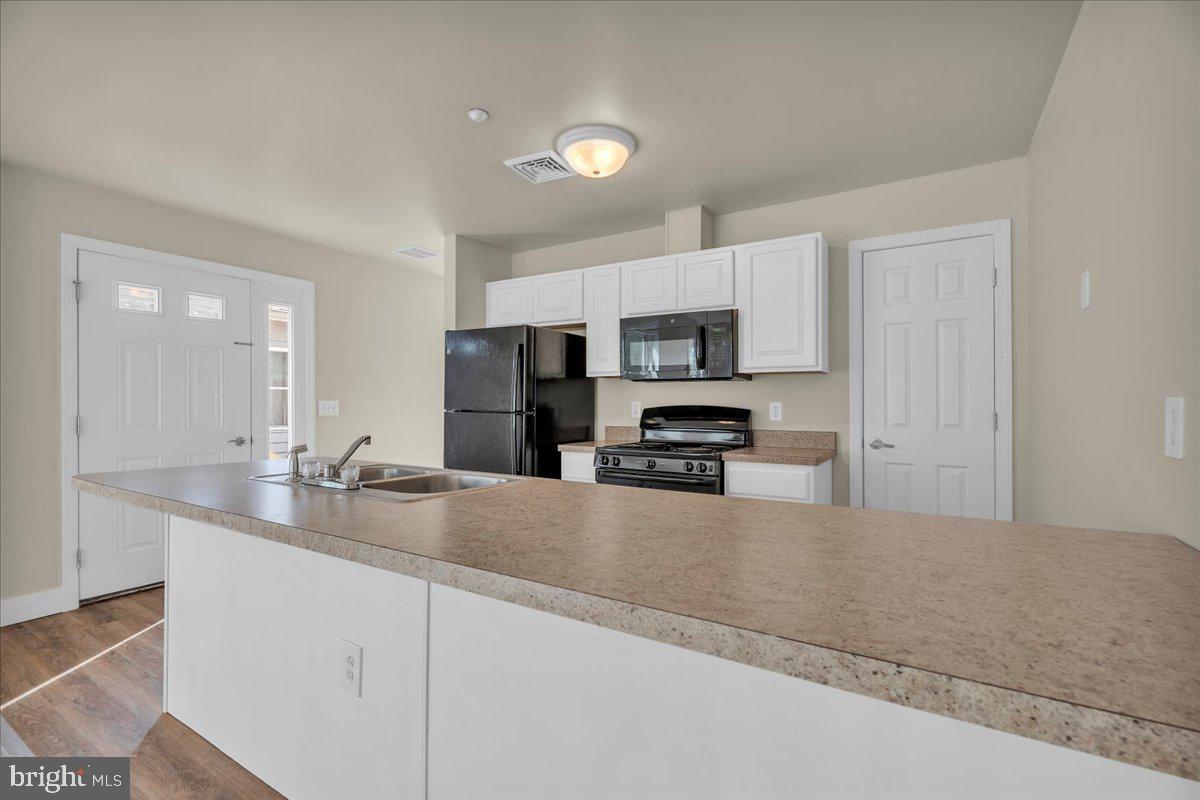 25 Eagle Street Bridgeton, NJ 08302 - Photo 12 of 24 a kitchen with stainless steel appliances a sink a stove a microwave a sink a refrigerator and cabinets