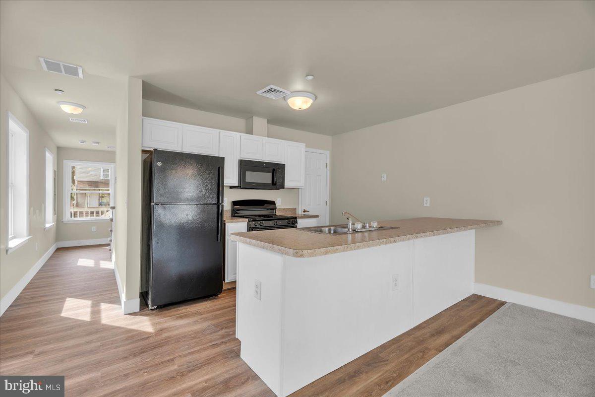25 Eagle Street Bridgeton, NJ 08302 - Photo 9 of 24 a kitchen with kitchen island a sink appliances and cabinets