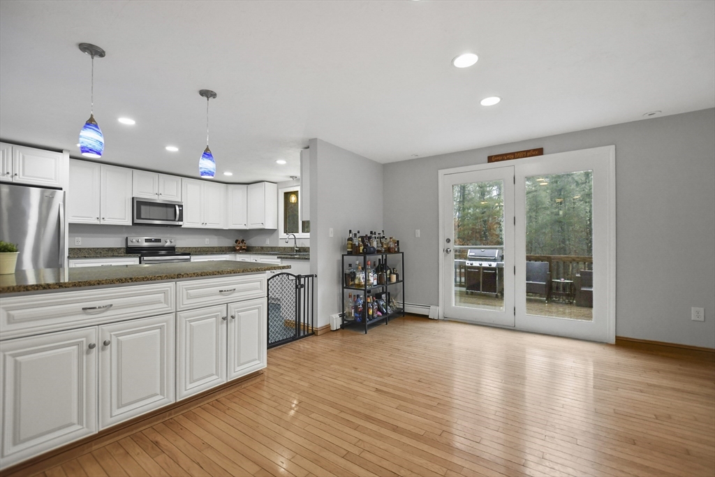 49 Howland Road Lakeville, MA 02347 - Photo 6 of 40 a kitchen with stainless steel appliances granite countertop a refrigerator oven a sink dishwasher and white cabinets with wooden floor