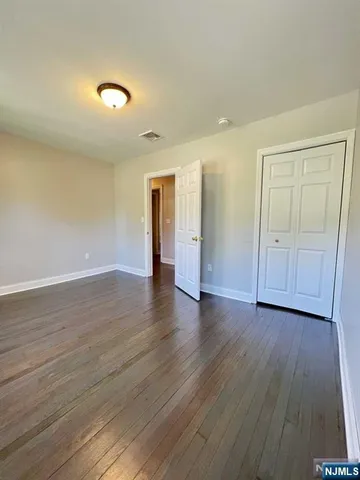 an empty room with wooden floor and closet