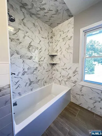 a bathroom with a bathtub and shower